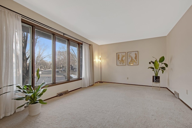 spare room with visible vents, baseboards, and carpet floors