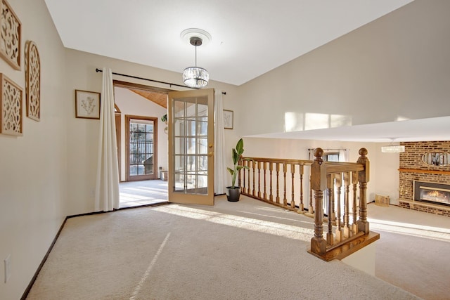 interior space with carpet floors, a brick fireplace, and vaulted ceiling