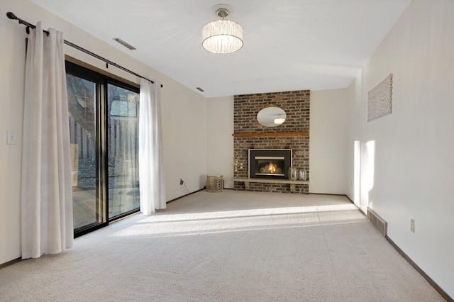 unfurnished living room featuring a brick fireplace, carpet, and visible vents