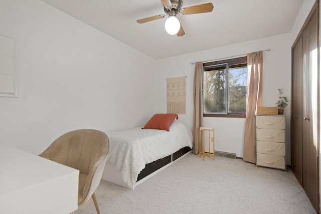 bedroom featuring visible vents, light carpet, and a ceiling fan