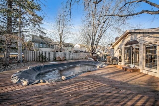 view of swimming pool with a deck, a fenced backyard, a fenced in pool, and french doors