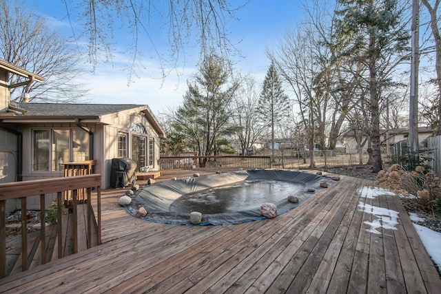 wooden terrace with grilling area, fence, and a hot tub