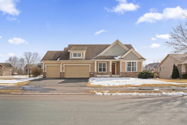 view of front of house featuring a garage, stone siding, and driveway