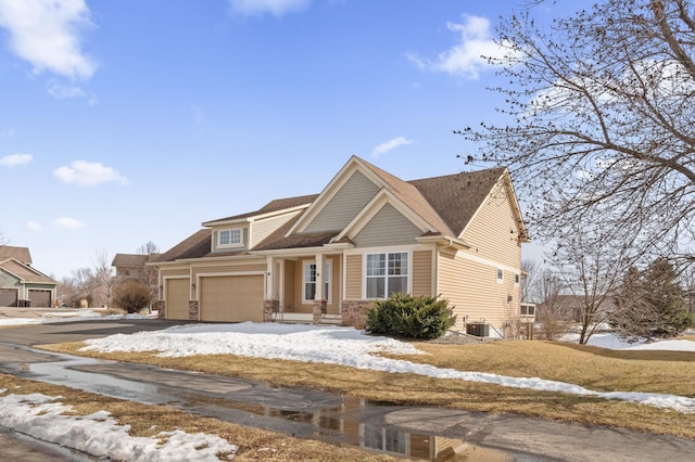 view of front of house with central air condition unit, a garage, and driveway