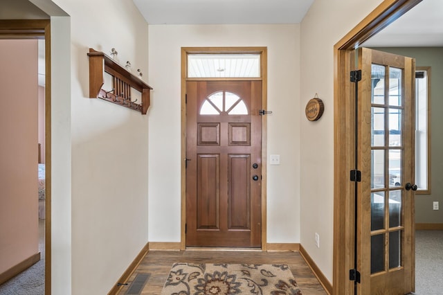 entrance foyer featuring visible vents, baseboards, and wood finished floors