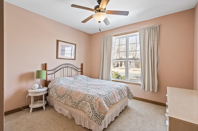 bedroom featuring a ceiling fan, light colored carpet, and baseboards