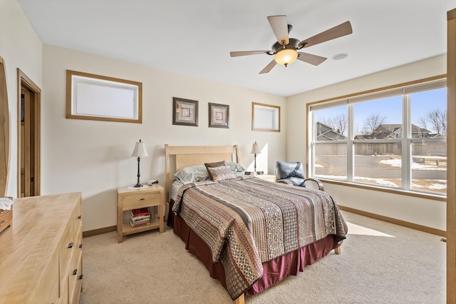 bedroom with ceiling fan, baseboards, and light carpet