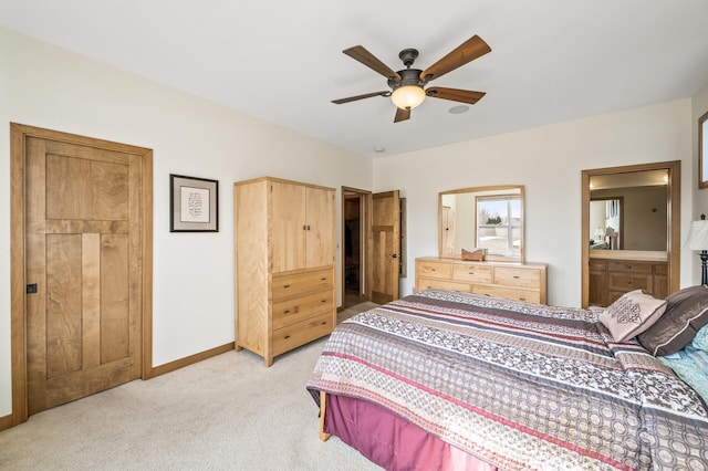 bedroom featuring light colored carpet, baseboards, ensuite bathroom, and ceiling fan