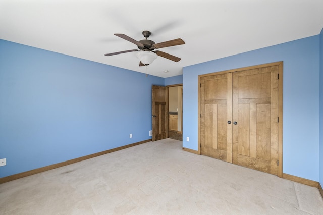 unfurnished bedroom featuring a closet, baseboards, carpet floors, and ceiling fan