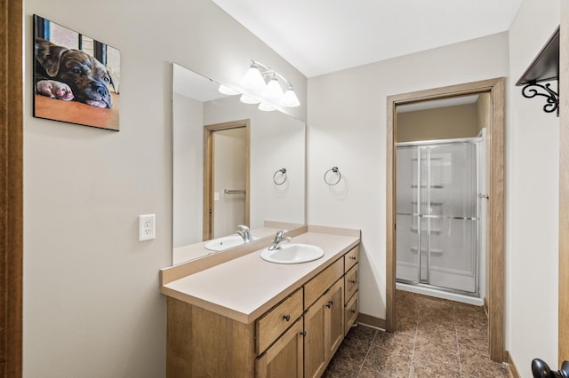 bathroom featuring vanity, baseboards, and a stall shower