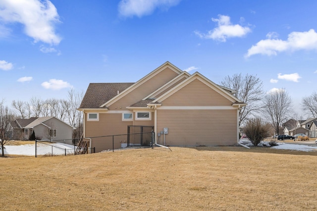 rear view of house with a yard and fence