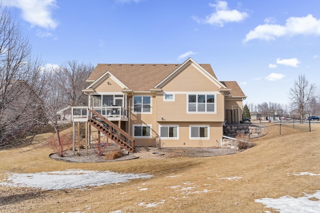 back of property featuring stairs, roof with shingles, and a sunroom