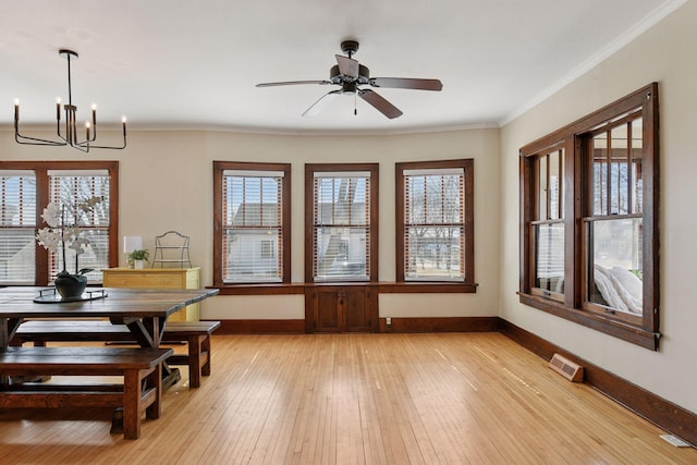 dining area featuring crown molding, light wood-style floors, and a healthy amount of sunlight