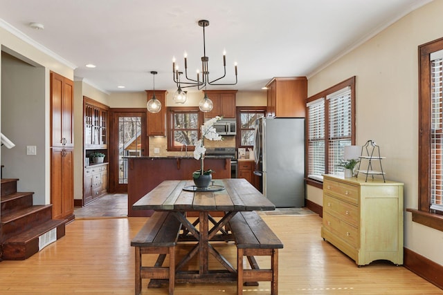 dining space with light wood-type flooring, plenty of natural light, and baseboards