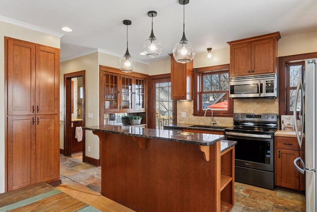 kitchen featuring a sink, stainless steel appliances, a kitchen bar, and stone tile flooring