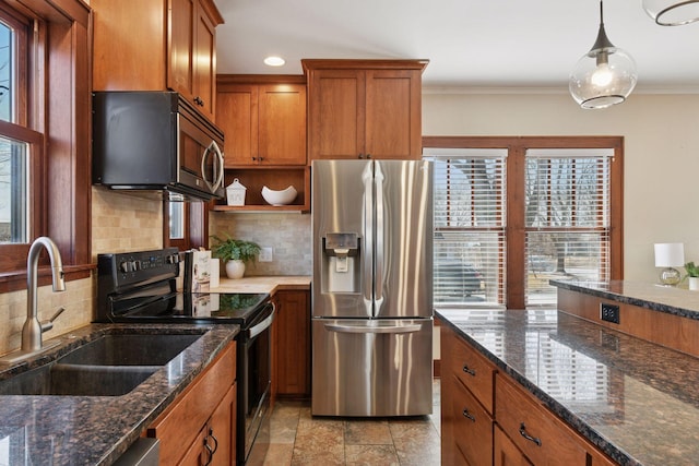 kitchen featuring brown cabinetry, a sink, decorative backsplash, stainless steel appliances, and crown molding