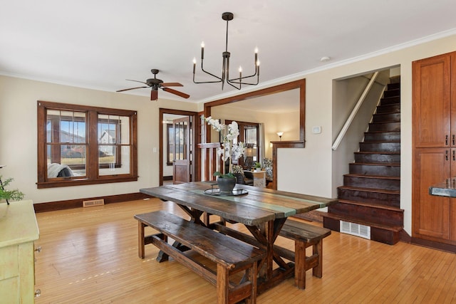 dining space with stairs, ornamental molding, visible vents, and light wood-type flooring