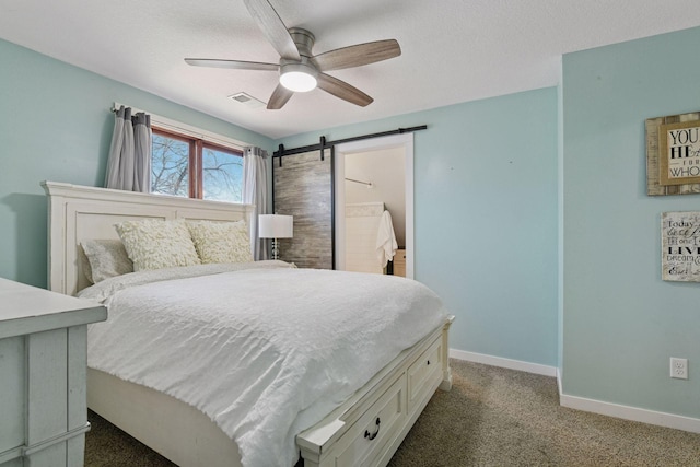 carpeted bedroom featuring a ceiling fan, baseboards, visible vents, a textured ceiling, and a barn door