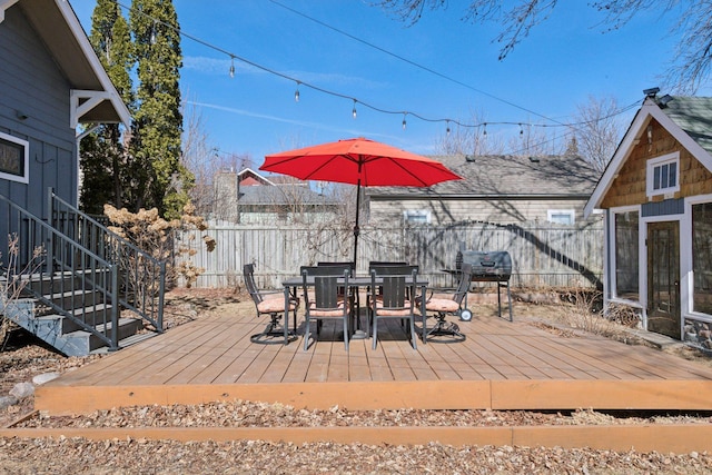 wooden terrace with outdoor dining area and fence