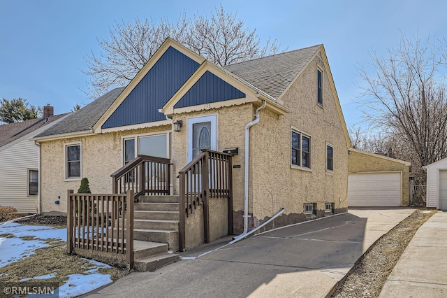 view of front of house featuring an outdoor structure, a garage, and roof with shingles