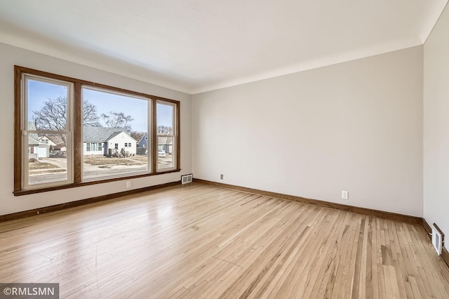 unfurnished room with light wood-style flooring, baseboards, and visible vents