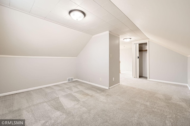 bonus room featuring lofted ceiling, visible vents, baseboards, and carpet floors