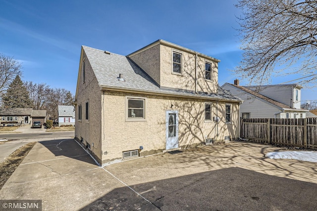 rear view of house featuring fence and stucco siding