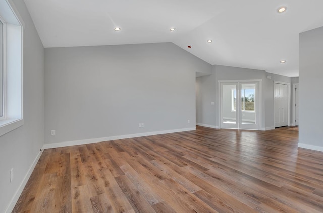 interior space featuring recessed lighting, baseboards, lofted ceiling, and wood finished floors