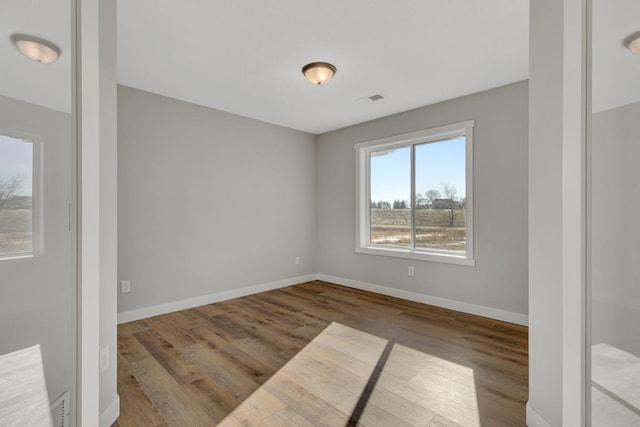 unfurnished room with wood finished floors and baseboards