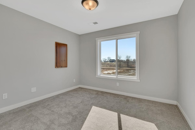 empty room featuring carpet flooring, visible vents, and baseboards