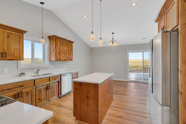 kitchen with brown cabinets, a kitchen island, appliances with stainless steel finishes, and a sink