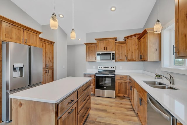 kitchen featuring light wood-style flooring, a sink, recessed lighting, appliances with stainless steel finishes, and hanging light fixtures