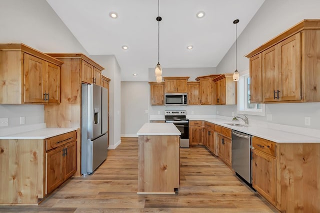 kitchen with a center island, light wood-type flooring, vaulted ceiling, appliances with stainless steel finishes, and a sink