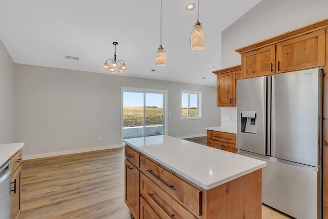 kitchen featuring baseboards, light wood-type flooring, light countertops, brown cabinets, and appliances with stainless steel finishes