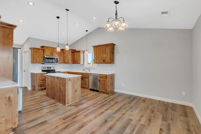 kitchen featuring visible vents, light wood-type flooring, a kitchen island, appliances with stainless steel finishes, and light countertops