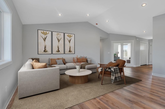 living room with recessed lighting, wood finished floors, baseboards, and vaulted ceiling