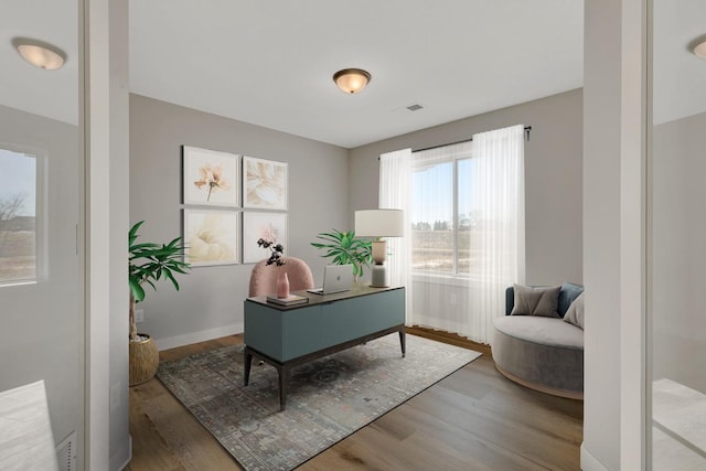 office area featuring visible vents, wood finished floors, and baseboards