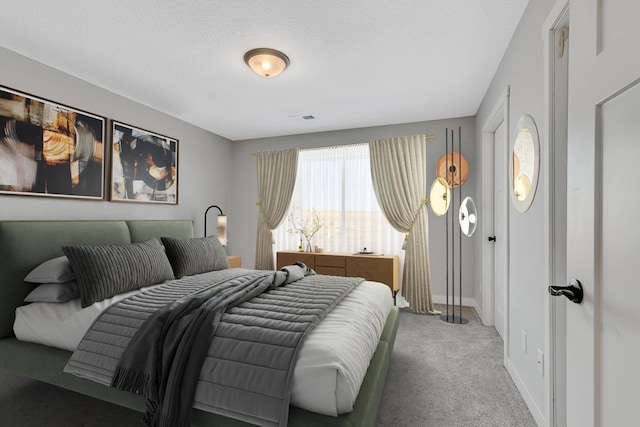 bedroom featuring visible vents, carpet, baseboards, and a textured ceiling