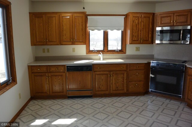 5501 70th St, Glencoe, MN 55336 - kitchen featuring stove, stainless steel microwave, paneled dishwasher, a sink, and brown cabinetry