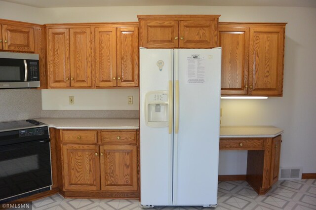 5501 70th St, Glencoe, MN 55336 - kitchen with white refrigerator with ice dispenser, stainless steel microwave, stove, and brown cabinets