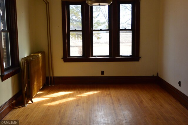 5501 70th St, Glencoe, MN 55336 - unfurnished room with radiator heating unit, wood finished floors, and baseboards
