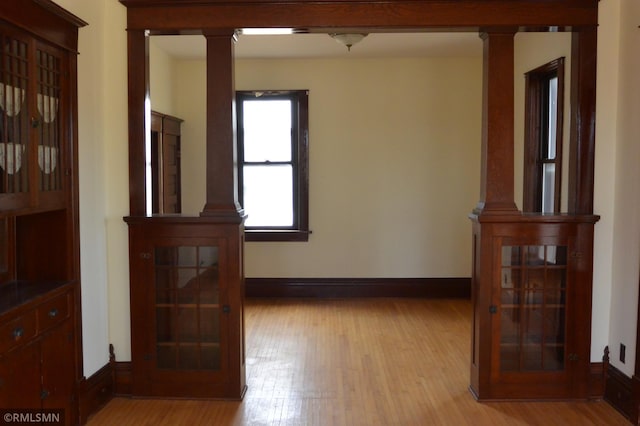 5501 70th St, Glencoe, MN 55336 - empty room with ornate columns, light wood-type flooring, and baseboards