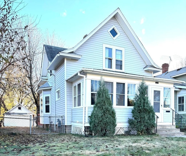 view of front of house with entry steps, fence, and roof with shingles