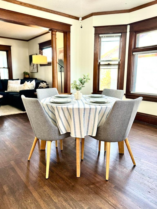 dining area with crown molding, baseboards, and wood finished floors