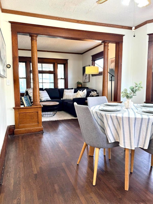 dining area with crown molding, wood finished floors, ornate columns, and a textured ceiling