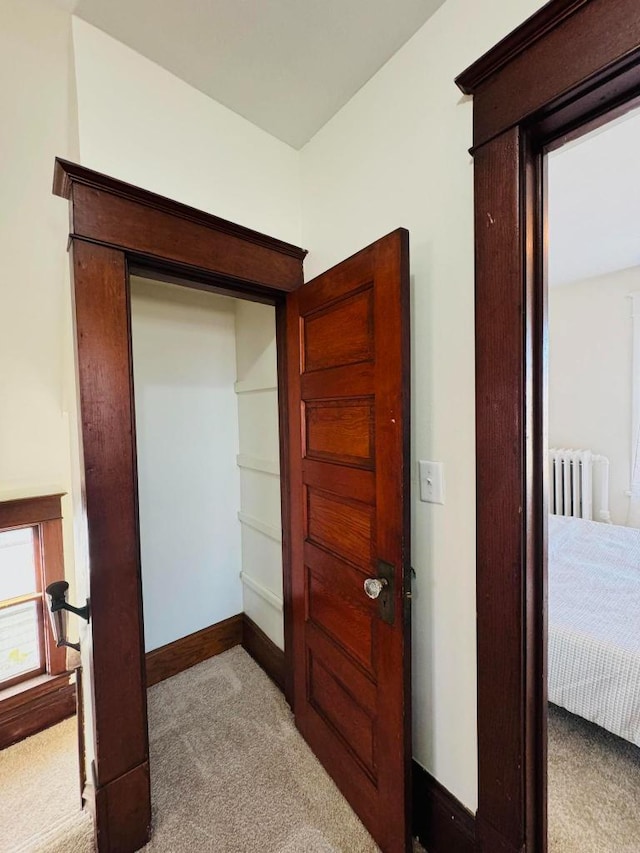 carpeted bedroom featuring radiator and baseboards