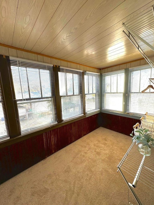 unfurnished sunroom with wood ceiling and a wealth of natural light