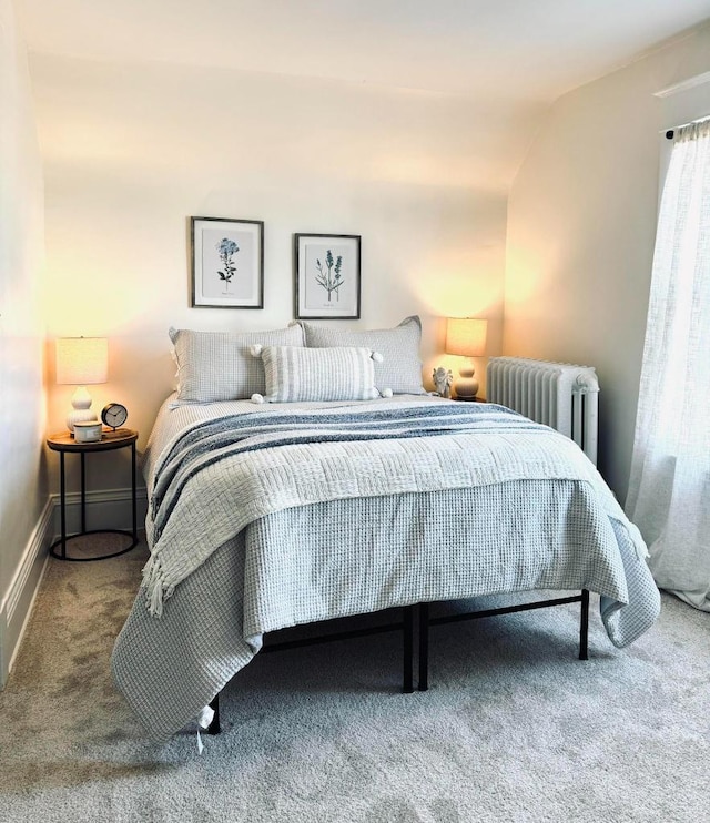 bedroom with radiator heating unit, baseboards, and carpet floors