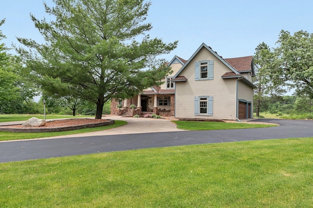 view of front of property featuring a front lawn, an attached garage, a porch, and driveway