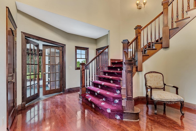 foyer entrance featuring stairs, wood finished floors, and baseboards